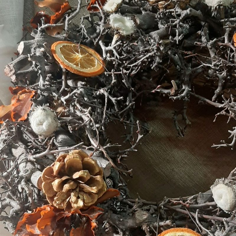 Corona de Navidad de ramas secas, frutos y flor preservada